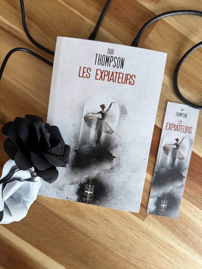Livre Les Expiateurs avec des câbles, des fleurs en papier noires et blanches